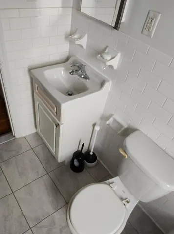 a bathroom with a sink toilet and a mirror