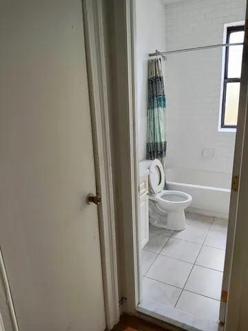 a bathroom with a toilet and a shower