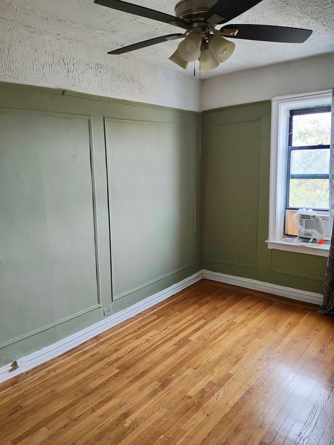 1015 Summit Avenue, Unit 6B Bronx, NY 10452 - Photo 18 of 21 an empty room with wooden floor fan and windows