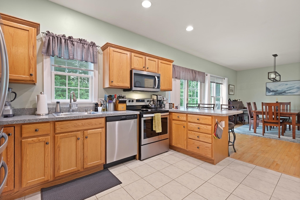 3 Knowlton Circle, Unit 3 Upton, MA 01568 - Photo 16 of 42 a kitchen with stainless steel appliances granite countertop a stove a sink dishwasher and a microwave oven with cabinets
