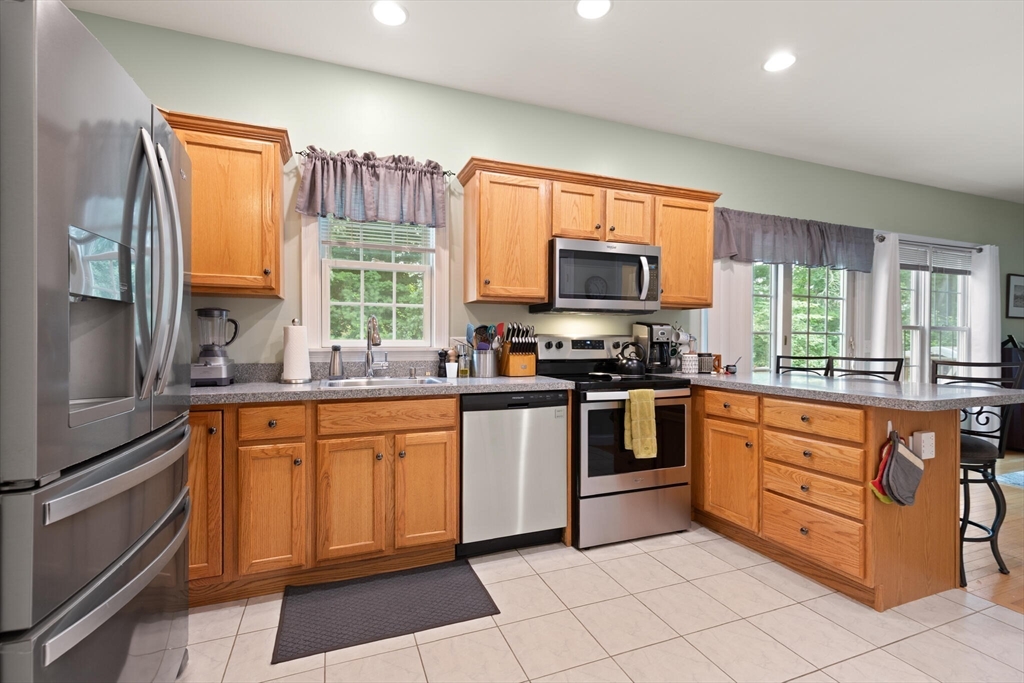 3 Knowlton Circle, Unit 3 Upton, MA 01568 - Photo 17 of 42 a kitchen with stainless steel appliances granite countertop a stove a sink and a refrigerator