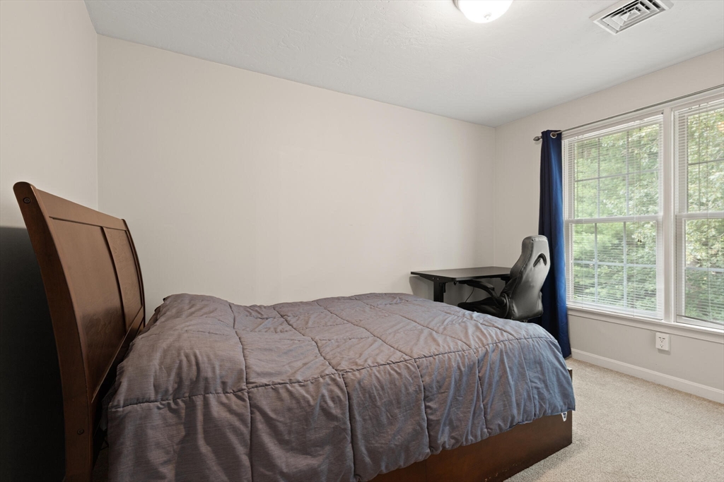 3 Knowlton Circle, Unit 3 Upton, MA 01568 - Photo 27 of 42 a bedroom with a bed and wooden floor