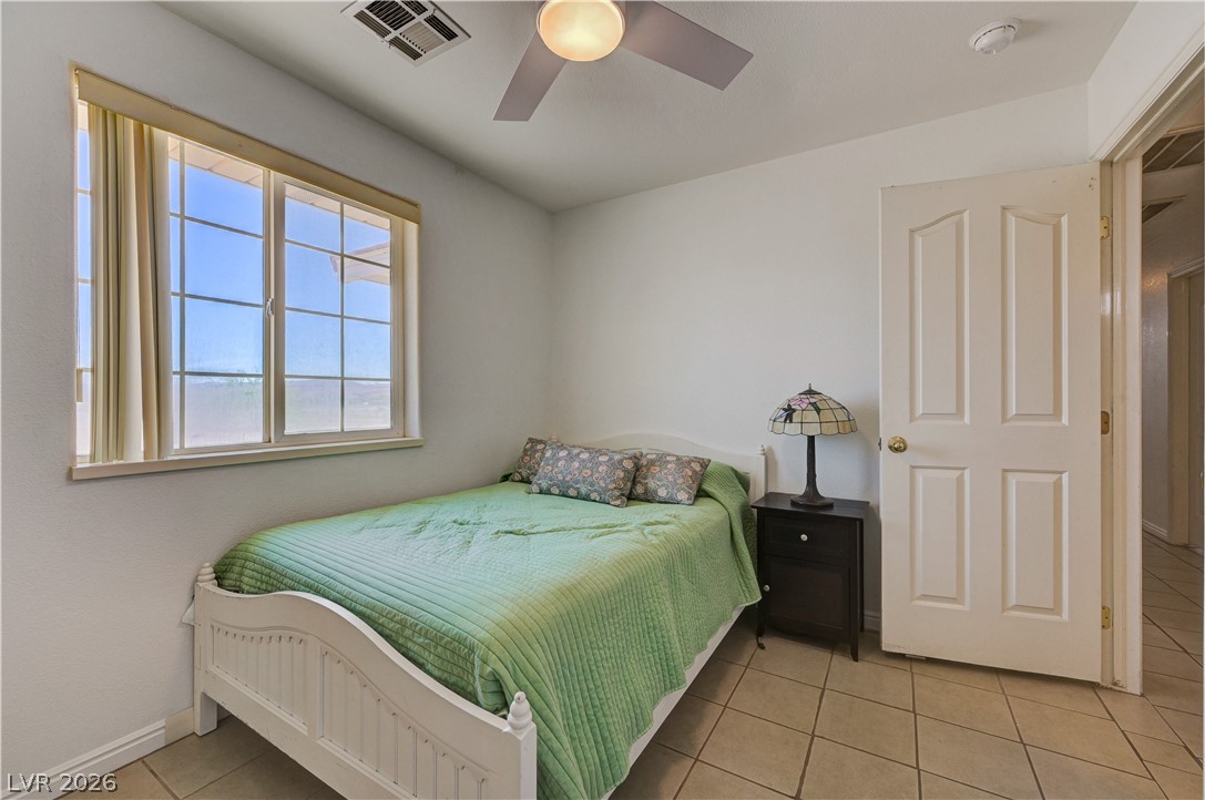 1272 Liston Avenue Logandale, NV 89021 - Photo 26 of 61 A well-lit bedroom features durable tile flooring and a ceiling fan for comfort.