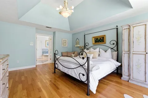a bedroom with a bed and a chandelier