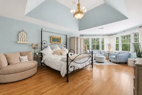 a spacious bedroom with a bed couch and a large window