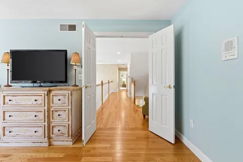 a view of room with wooden floor and flat screen tv