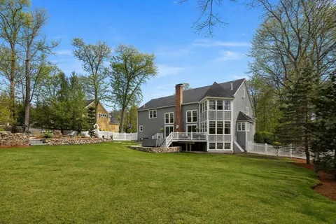 a view of a house with a big yard and large trees