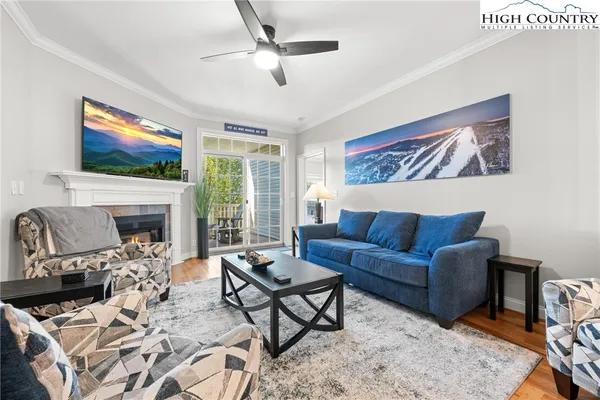 a living room with furniture a flat screen tv and a fireplace