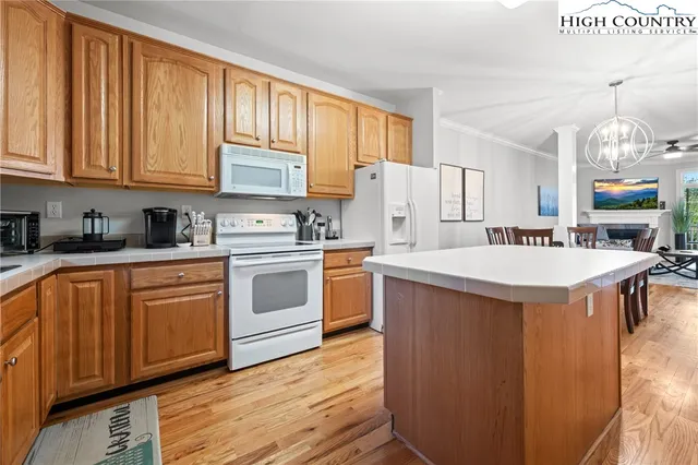 a kitchen with stainless steel appliances granite countertop a stove a sink dishwasher and a refrigerator with wooden floor