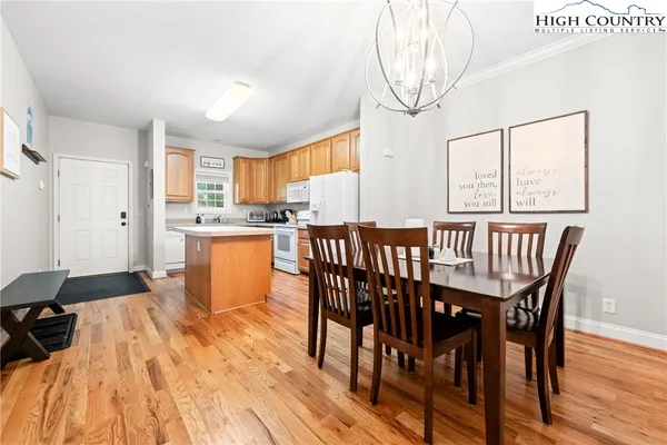 a dining room with stainless steel appliances a table and chairs