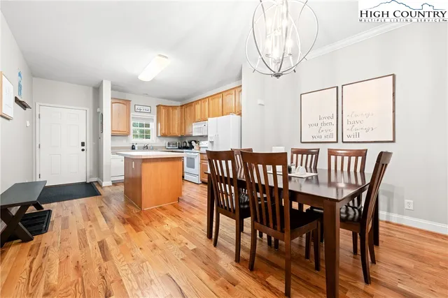 a dining room with stainless steel appliances a table and chairs