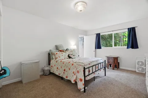a bed sitting in a bedroom next to a window