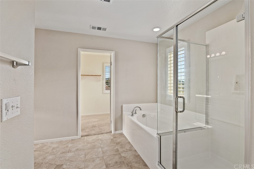 46945 Peach Tree Street Temecula, CA 92592 - Photo 19 of 32 a bathroom with a bathtub and shower