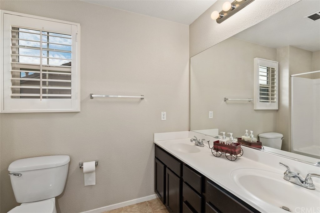 46945 Peach Tree Street Temecula, CA 92592 - Photo 25 of 32 a bathroom with a granite countertop sink toilet and mirror