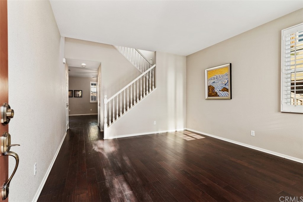 46945 Peach Tree Street Temecula, CA 92592 - Photo 4 of 32 a view of a hallway with wooden floor and stairs