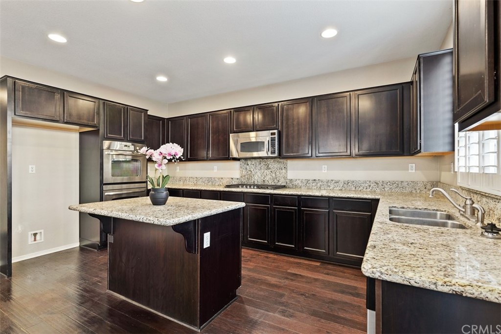 46945 Peach Tree Street Temecula, CA 92592 - Photo 8 of 32 a kitchen with kitchen island granite countertop stainless steel appliances a sink stove and refrigerator