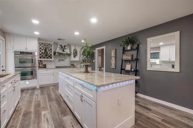 a kitchen with kitchen island granite countertop lots of counter top space and stainless steel appliances