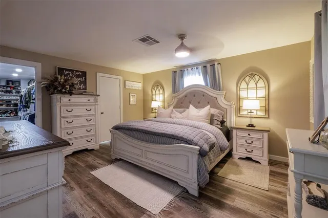 a spacious bedroom with a bed and a dresser