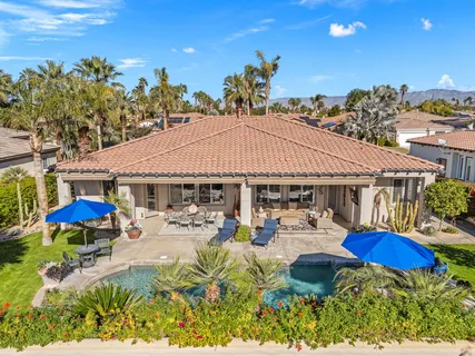 an aerial view of a house with a yard and mountain view in back