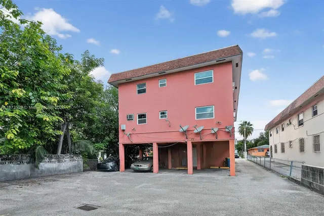 a front view of a building with large trees