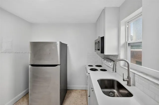 a kitchen with a sink and a refrigerator