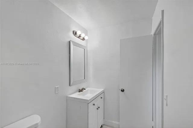 a bathroom with a toilet a sink and mirror