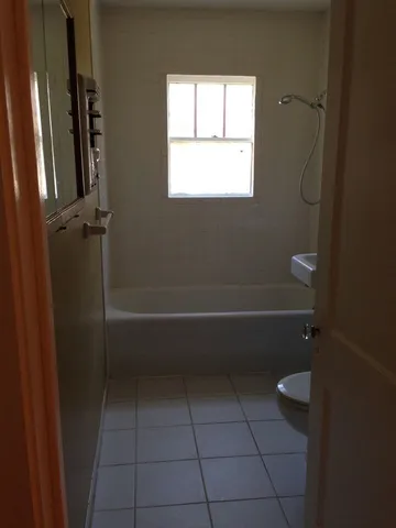 a bathroom with a granite countertop toilet a sink and shower