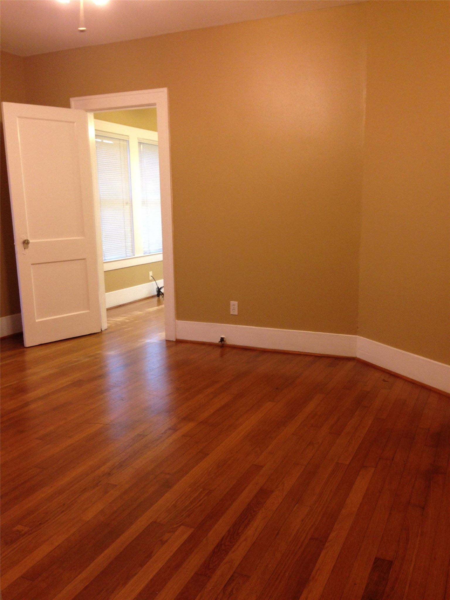 1719 Dunlavy Street Houston, TX 77006 - Photo 6 of 16 a view of an empty room with wooden floor and a window