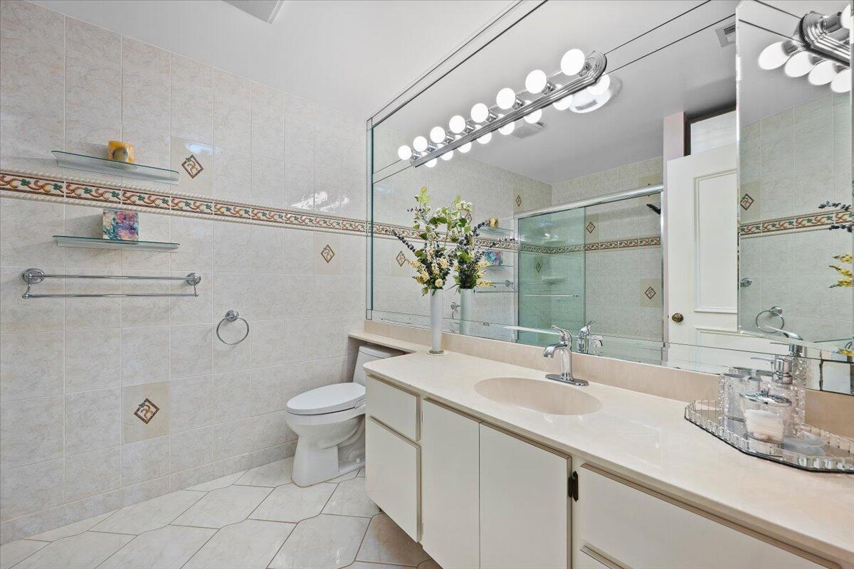 352 River Edge Road Jupiter, FL 33477 - Photo 23 of 56 a bathroom with a sink a toilet and mirror