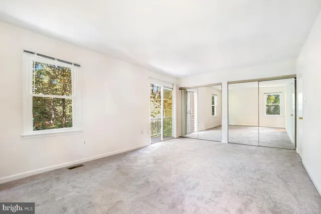 an empty room with windows and closet