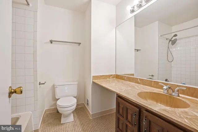 a bathroom with a granite countertop sink a toilet and shower