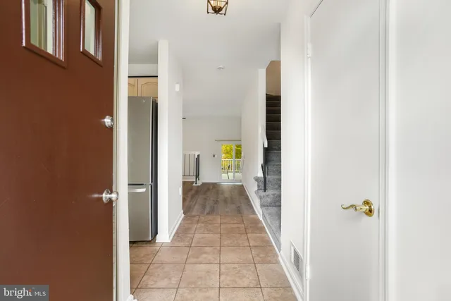 a view of a hallway with wooden floor and a bathroom