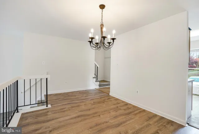 a view of empty room with wooden floor and ceiling fan