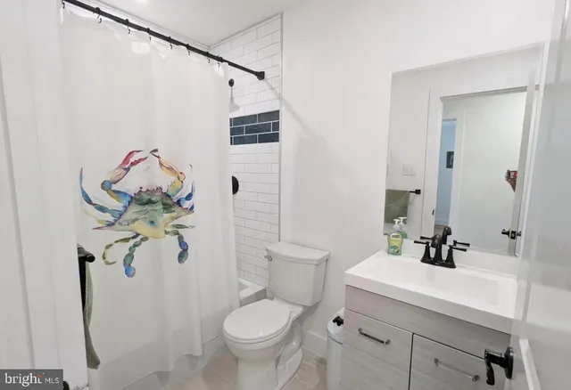 a bathroom with a sink mirror vanity and toilet