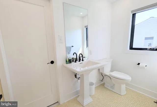 a bathroom with a sink a toilet and a mirror