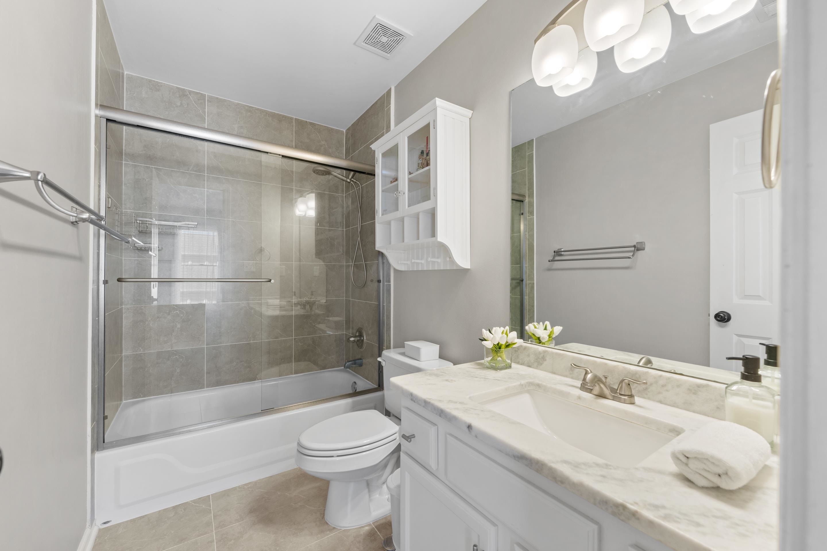 1339 Winoka Road Collierville, TN 38017 - Photo 38 of 40 a bathroom with a granite countertop sink a toilet and shower