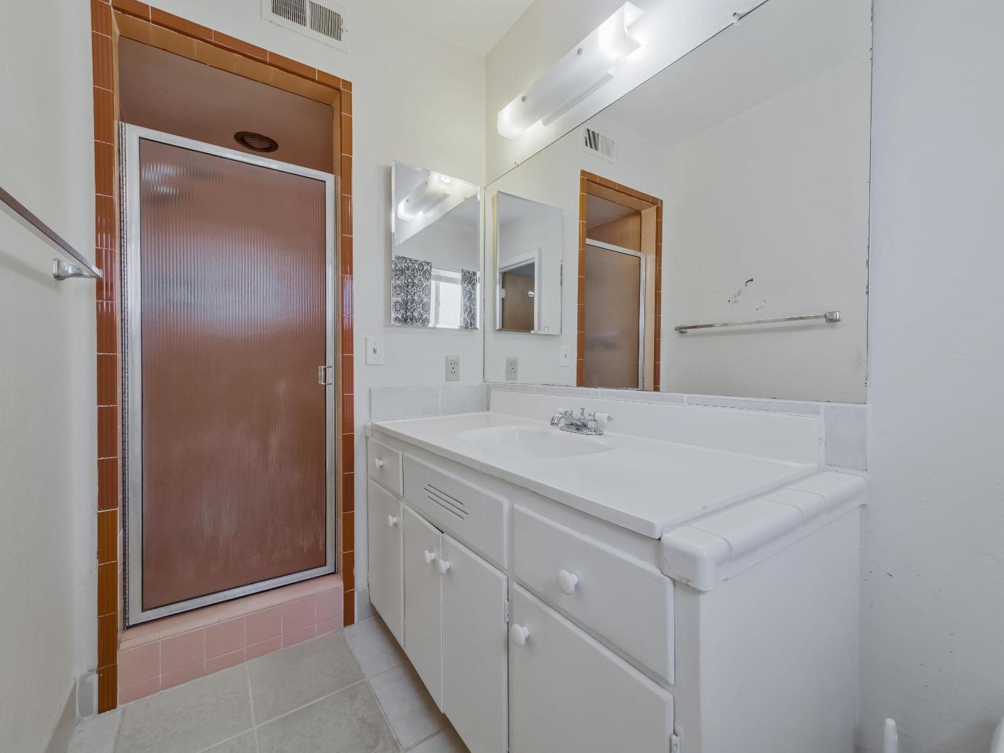 21 El Cerrito Avenue San Mateo, CA 94402 - Photo 11 of 13 a bathroom with a sink a shower a mirror and a vanity
