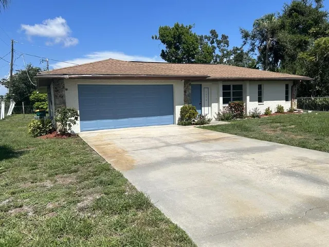 a front view of a house with a garden and yard