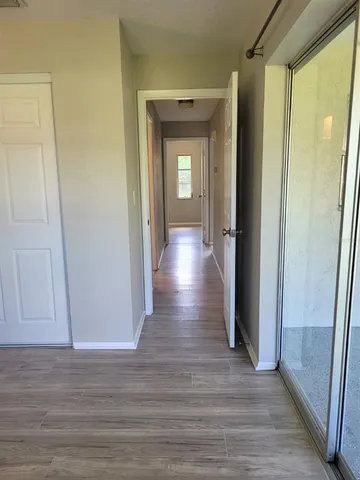a view of a hallway with wooden floor