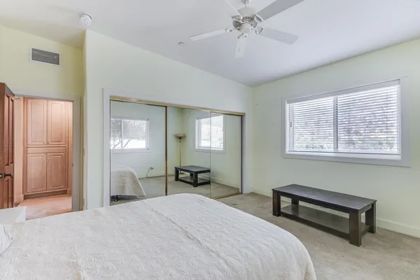 a spacious bedroom with a bed and a dresser in it