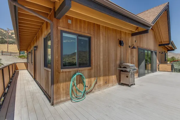 a view of a patio with table and chairs with wooden floor and fence