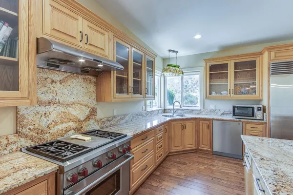 a kitchen with stainless steel appliances granite countertop a stove and a sink