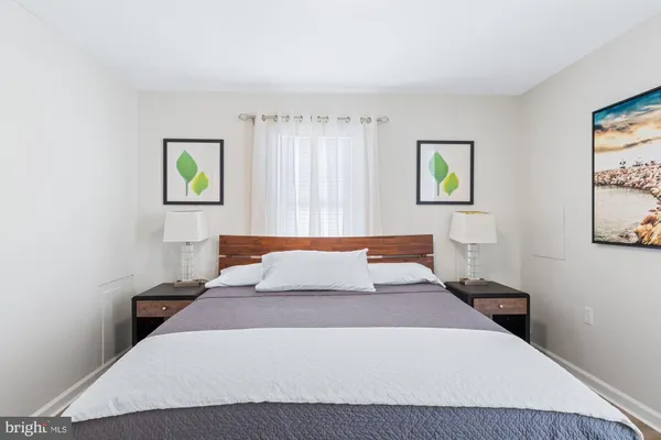 a bedroom with a bed and painting on the wall