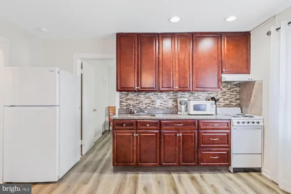 a kitchen with stainless steel appliances granite countertop a refrigerator and a stove top oven