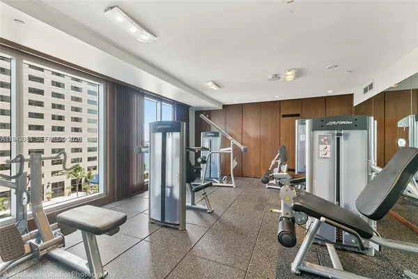 a living room with furniture a large window and wooden floor