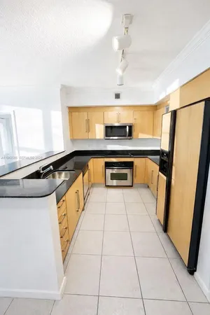 a kitchen with stainless steel appliances a refrigerator a sink a stove and cabinets