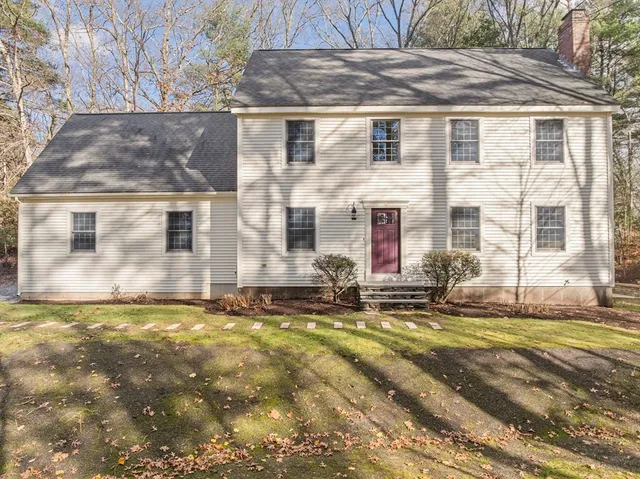 a view of a brick house with many windows next to a road