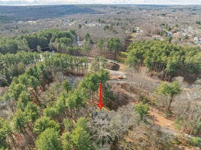 an aerial view of residential houses with outdoor space and trees