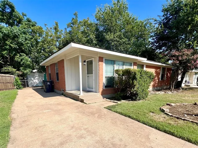 a view of a house with backyard and trees