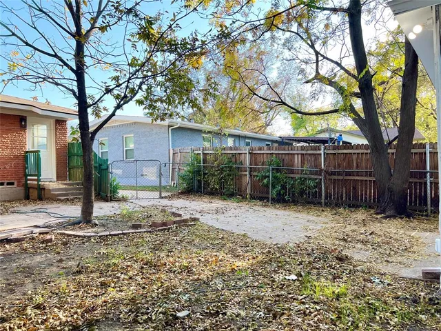 a backyard of a house with large trees and garage
